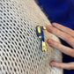 Détails du pins toucan porté sur un gilet, broche bleue et dorée