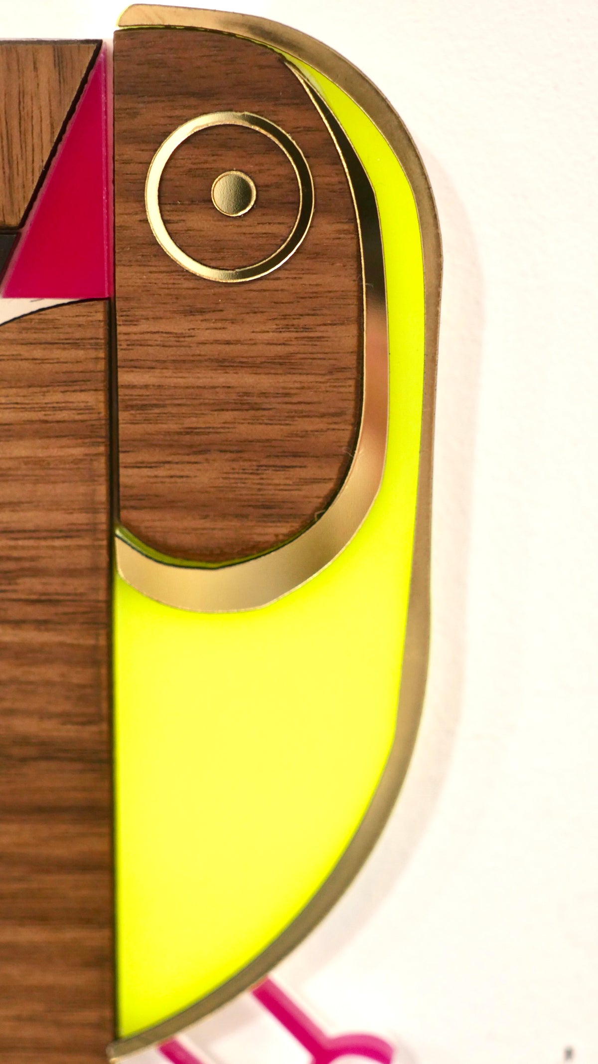 Zoom œil de la décoration murale Toucan jaune et rose, plexiglas coloré et bois, fait main en France